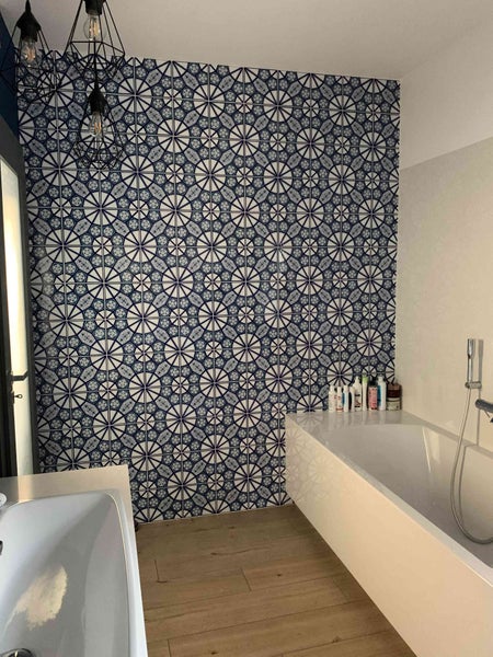 Modernes Badezimmer mit gemusterten Fliesen und Badewanne