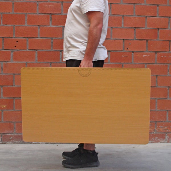 Eine Person trägt ein Zeichenbrett aus Holz.