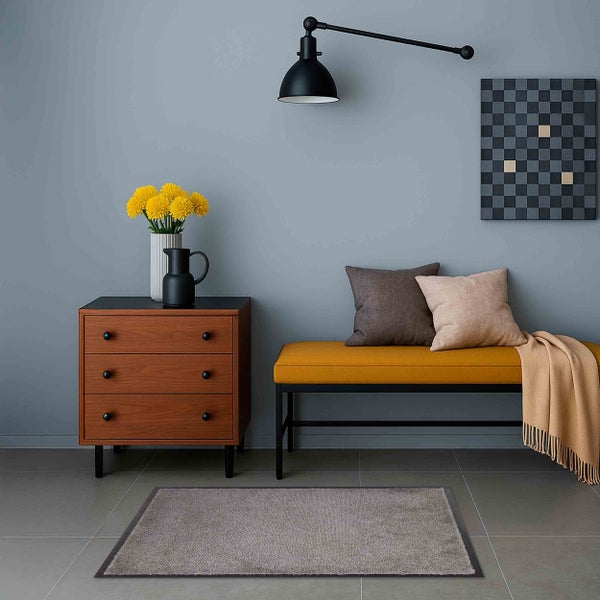 Wohnzimmer mit Kommode, Bank, Kissen, Teppich und Dekoration.