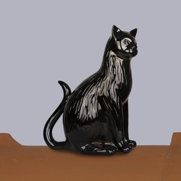 Glänzend schwarze Dekofigur in Form einer sitzenden Katze aus Keramik.