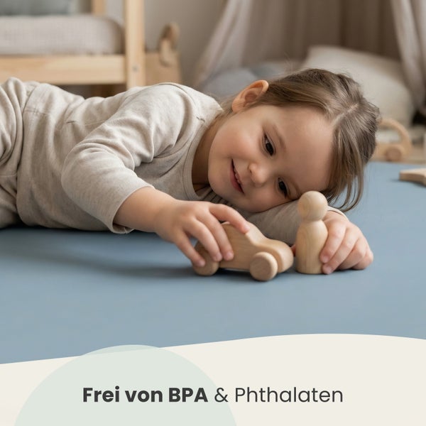 Ein Kind spielt auf einer hellblauen Spielmatte mit Holzspielzeug, frei von Bisphenol A und Phthalaten.