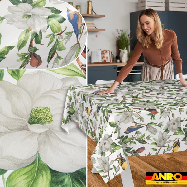 Abwischbare Tischdecke mit Magnolien- und Vogelmotiv, präsentiert von einer Frau in einer hellen Küche, Detailansichten des Musters, ANRO Logo.