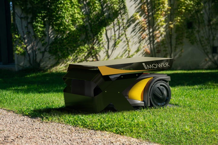 Rasenmähroboter auf einer Rasenfläche vor einer Hauswand