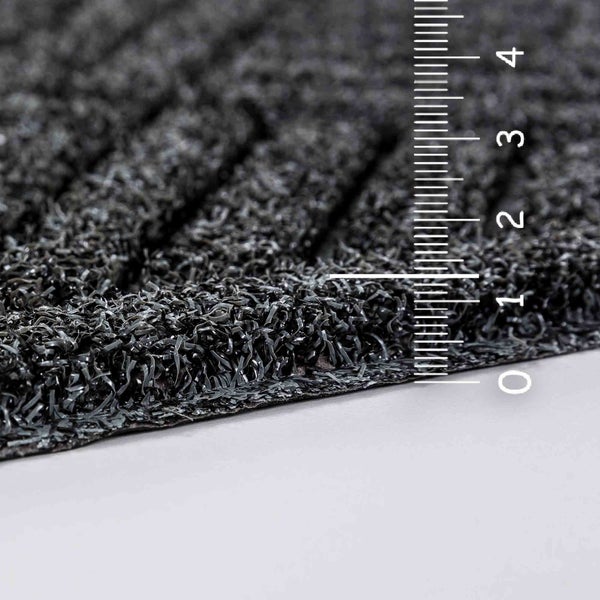 Detailansicht einer schwarzen Schmutzfangmatte mit Messskala zur Darstellung der Dicke