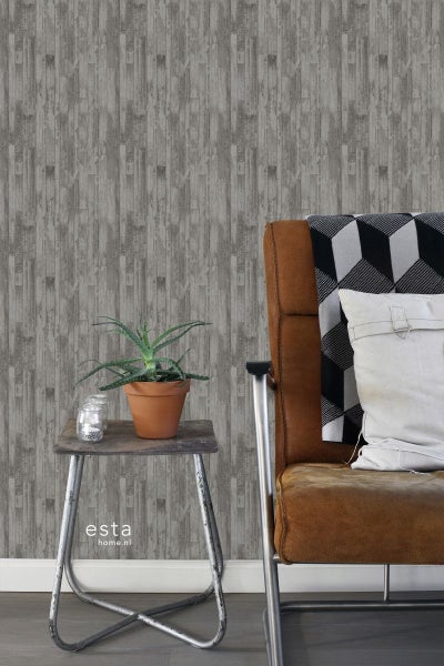 Raumansicht mit grauer Holzwandtapete, Sessel und Beistelltisch