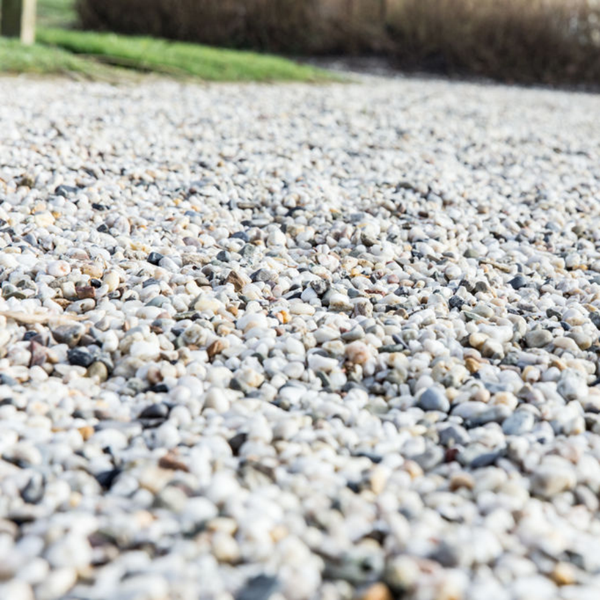 Zierkies aus hellen Flusssteinen in verschiedenen Nuancen für die Gestaltung von Gartenwegen und Beeten.
