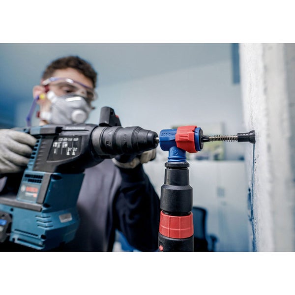 Eine Person hämmert einen Dübel in eine Wand. Ein Hammer ist sichtbar.