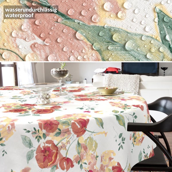 Runde Tischdecke mit Blumenmuster und wasserundurchlässiger Oberfläche, auf einem Tisch und in Nahaufnahme mit Wassertropfen dargestellt.