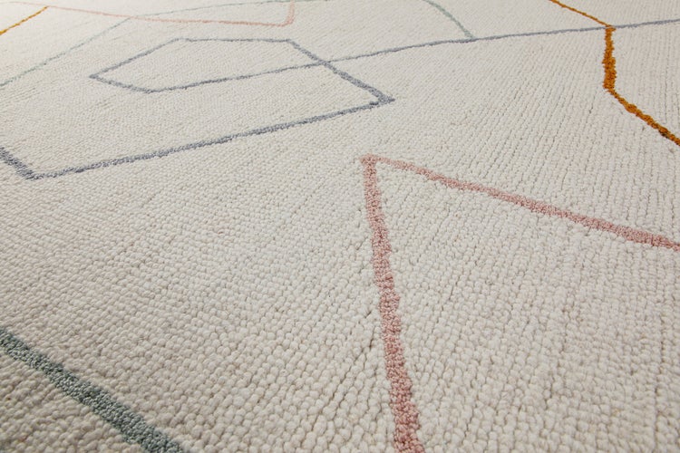Detailaufnahme eines gewebten Teppichs mit geometrischem Muster aus feinen, farbigen Linien auf hellem Untergrund.