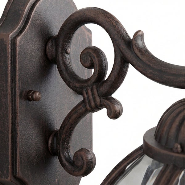 Detailansicht einer bronzefarbenen Wandleuchte mit dekorativen Verzierungen