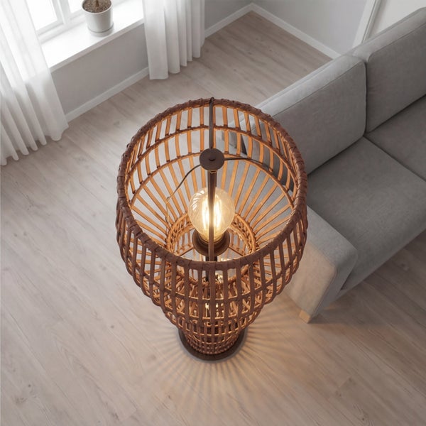 Moderne Stehlampe aus Rattan-Geflecht in einem hellen Wohnzimmer neben einem grauen Sofa.
