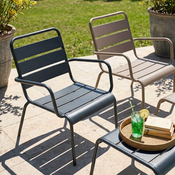 Gartensessel und Beistelltisch aus Metall im Latten-Design auf einer sonnigen Terrasse.