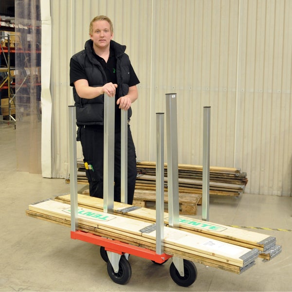 Mann mit Transporthilfe zum Bewegen von Holzmaterialien im Lager.