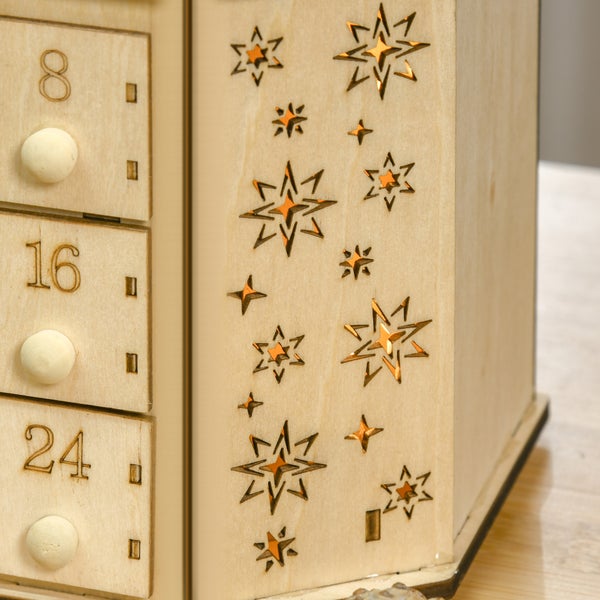 Nahaufnahme eines Adventskalenders aus Holz mit nummerierten Schubladen und dekorativen Sternenaussparungen.