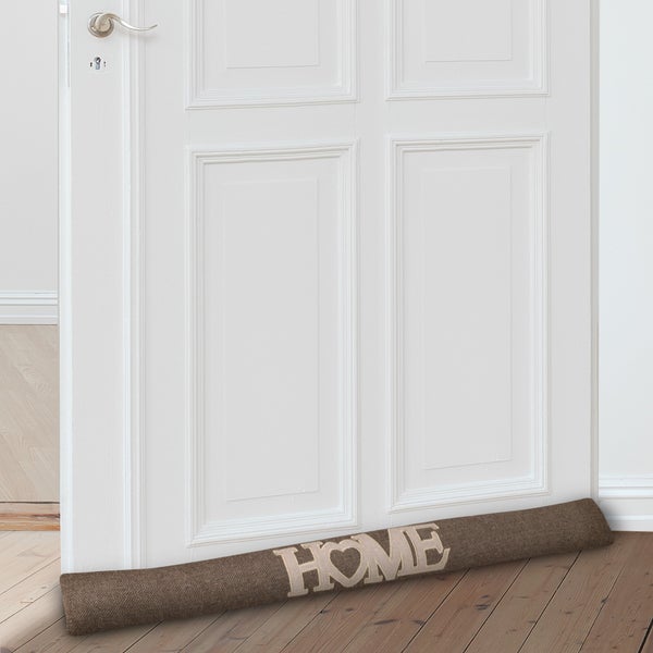 Zugluftstopper aus Textil mit der Aufschrift HOME vor einer Tür