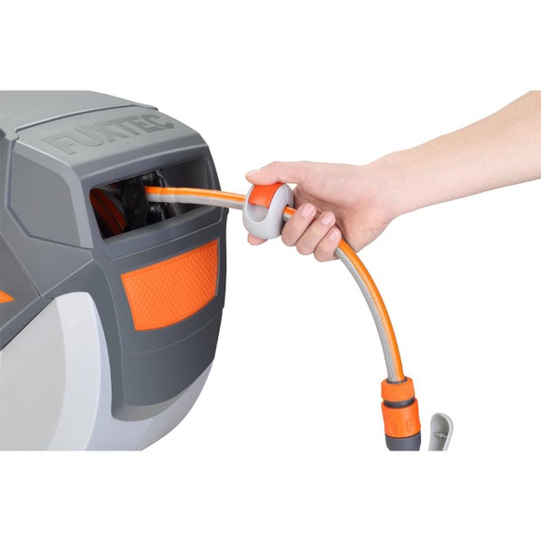 Hand zieht einen flexiblen Gartenschlauch aus einer Schlauchbox von Fuxtec