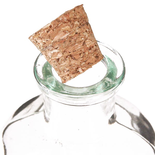 Naturkorken wird in den Hals einer transparenten Glasflasche gesetzt.