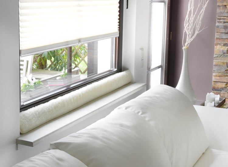 Szene mit Fenster, Plissee, Fensterdichtung und Kissen.