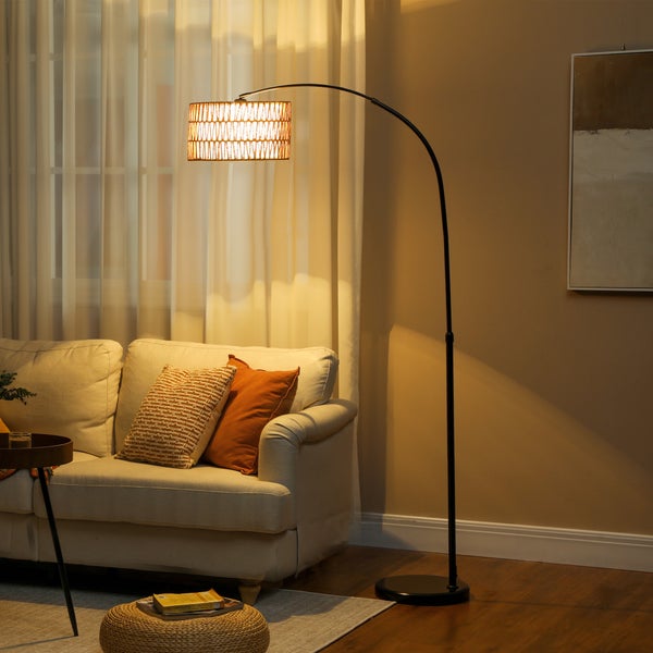 Bogenlampe mit Rattanlampenschirm neben Sofa im Wohnzimmer