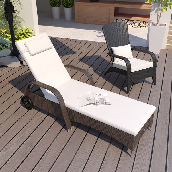 Gartenliege und Sessel aus Polyrattan mit Polstern auf einer Terrasse aus Holz.
