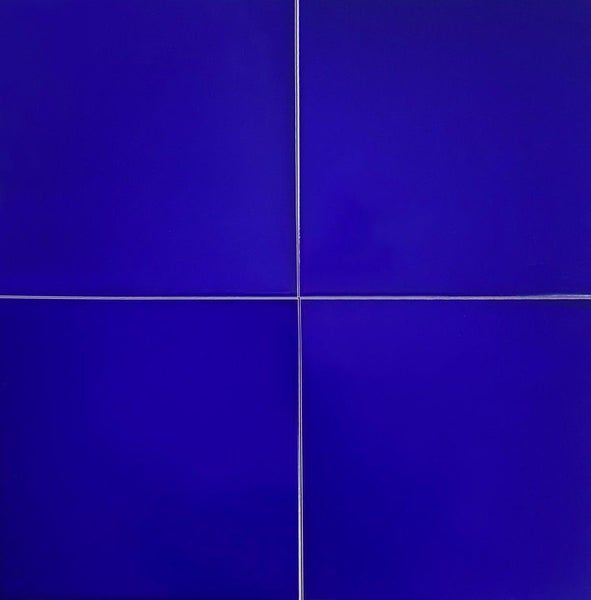 Vier blaue Keramikfliesen mit Fugen