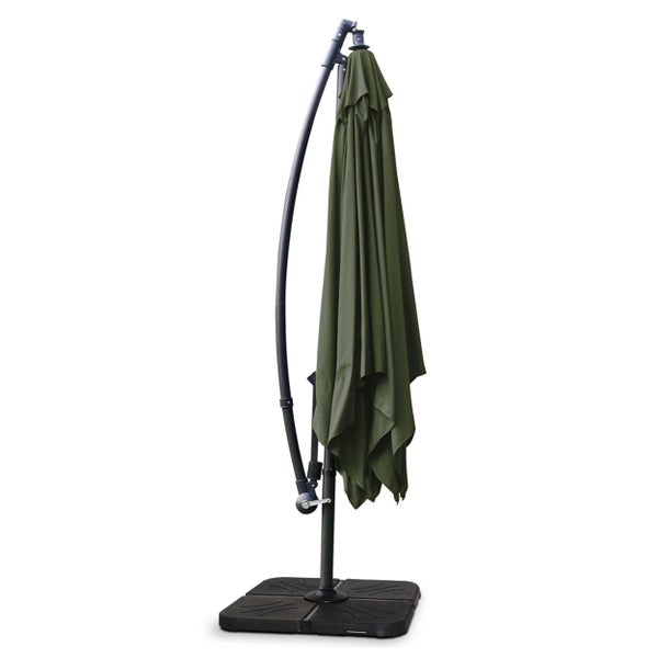 Geschlossener Ampelschirm mit grünem Bezug, gebogenem dunklem Gestell und Schirmständer.