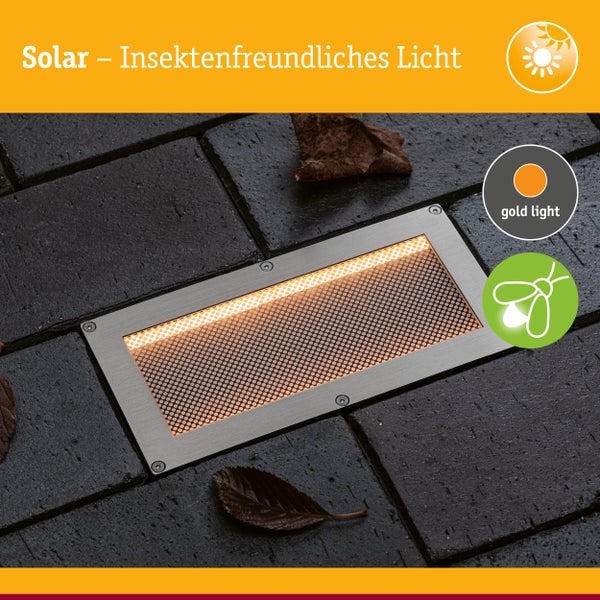 Rechteckige Solar-Bodeneinbauleuchte aus Edelstahl mit insektenfreundlichem goldenem Licht, eingebaut in Steinpflaster.