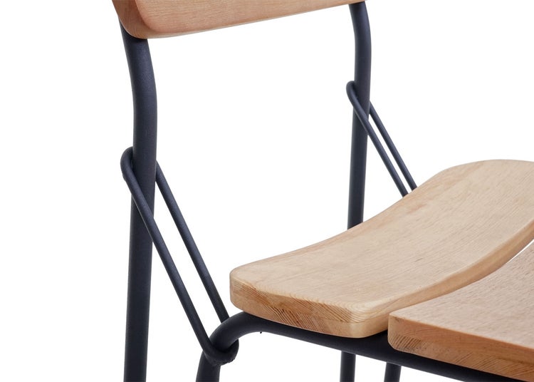 Detailansicht eines Stuhls mit Holzlehne und Sitzfläche auf einem Metallgestell