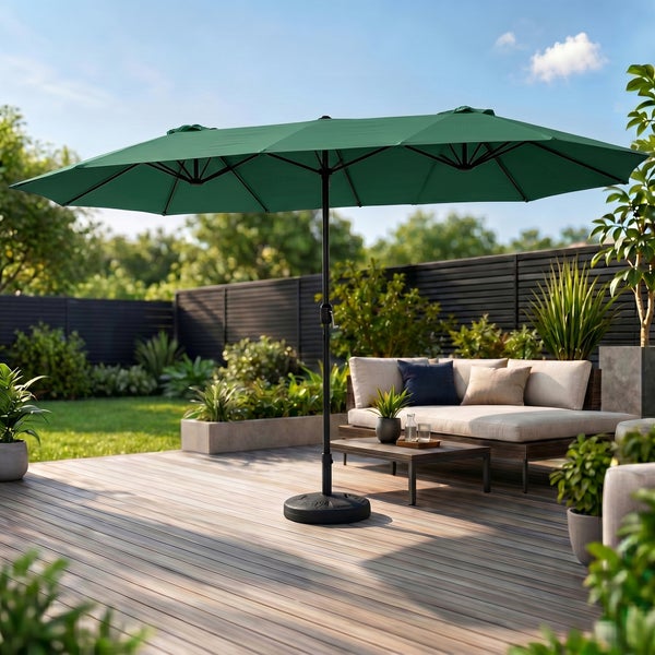 Großer grüner Doppelsonnenschirm auf einer Holzterrasse neben Gartenmöbeln in einem modernen Garten.