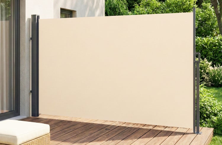 Ausgezogene Seitenmarkise auf einer Terrasse mit Holzfußboden als Sichtschutz und Sonnenschutz vor einer grünen Hecke.