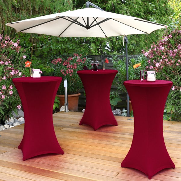 Szene im Garten mit drei Stehtischen mit Husse und einem Sonnenschirm