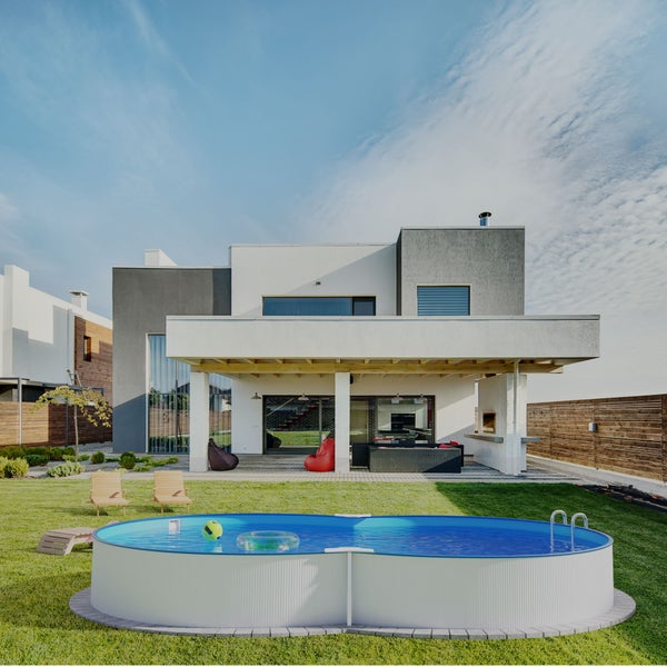 Garten mit modernem Haus, Aufstellpool, Gartenmöbeln und Rasen