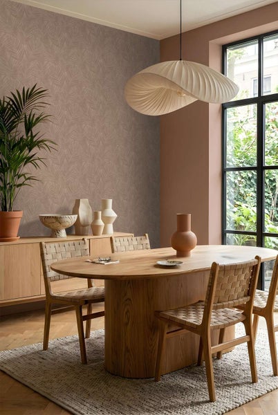 Modernes Esszimmer mit gemusterter Tapete, ovalem Holztisch, Holzstühlen mit geflochtener Sitzfläche und einer organisch geformten Pendelleuchte.