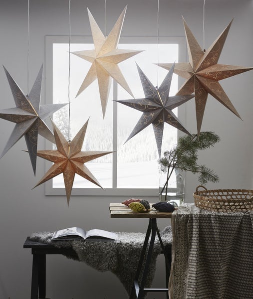 Dekorative Szene mit Sternenlampen, Tisch und Textilien für eine festliche Atmosphäre