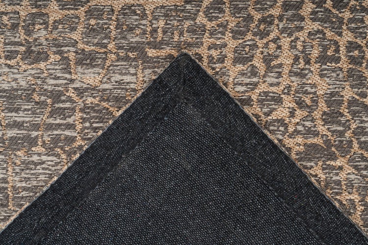 Nahaufnahme eines strukturierten Teppichs mit Tiermuster und dunkler gewebter Rückseite.