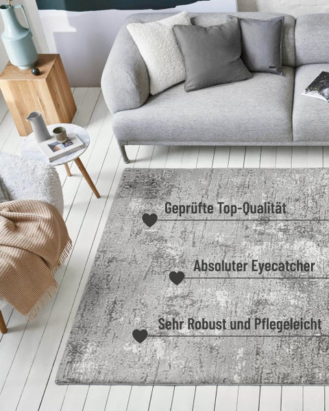 Moderner Wohnbereich mit grauem Teppich im Vintage-Stil vor einem Sofa. Der Teppich ist robust, pflegeleicht und hochwertig verarbeitet.