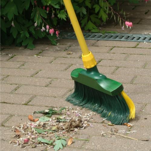 Kehrbesen mit Pflanzenresten auf Pflastersteinen