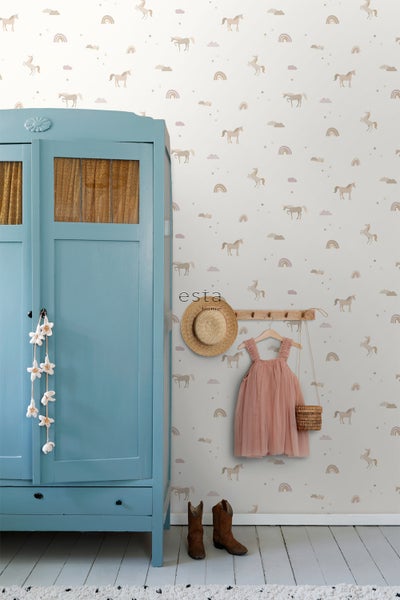Kinderzimmer mit blauem Schrank, Kleiderhaken mit Kleid, Hut und Tasche sowie Tapete mit Einhornmuster