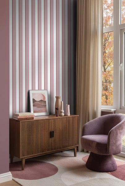 Modernes Zimmer mit gestreifter Tapete, geriffeltem Holzsideboard, lila Sessel und Teppich mit Kreismustern.