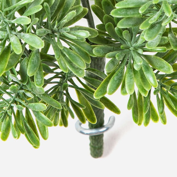 Künstliche rosa Ranunkel mit grünem Stiel und gezackten Blättern.