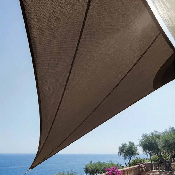 Dreieckiges Sonnensegel über einer Terrasse mit Blick auf das Meer und Bäume.