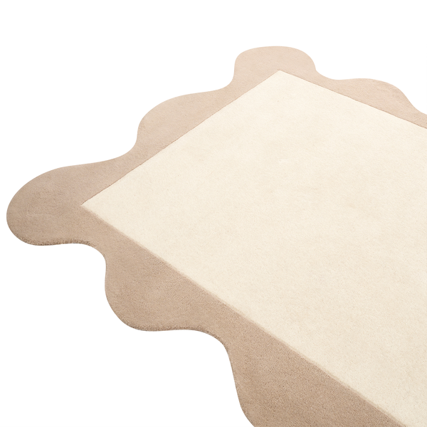 Rechteckiger Teppich mit gewelltem Rand aus weichem Material.