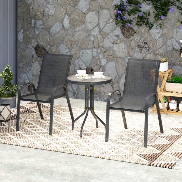 Modernes Gartenmöbel-Set bestehend aus zwei schwarzen Stapelstühlen mit Textilbespannung und einem runden Bistrotisch auf einem Außenteppich.