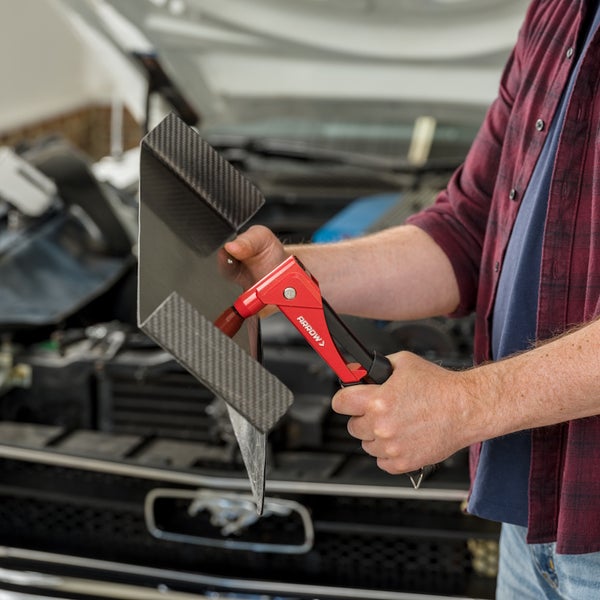 Arrow Handnietzange bei der Arbeit an einem Karosserieteil aus Carbon im Motorraum eines Autos.