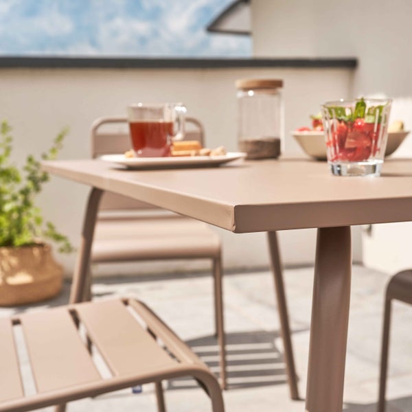 Braunes Gartenmöbel-Set aus Metall auf einer hellen Terrasse, bestehend aus einem Gartentisch und Gartenstühlen.