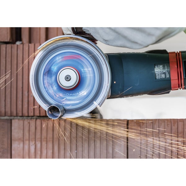 Eine Trennscheibe in Aktion beim Schneiden eines Metallrohrs, wobei Funken fliegen.