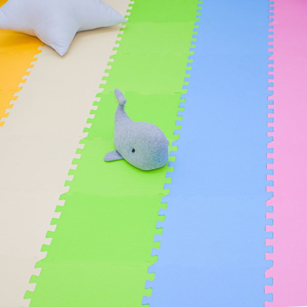 Mehrfarbige Spielmatte aus Schaumstoff als Puzzle für Kinderzimmer mit Spielzeugwal und Kissen
