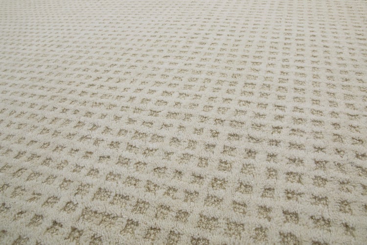 Strukturierter Teppichboden mit geometrischem Waffelmuster und weicher Oberflächenstruktur.