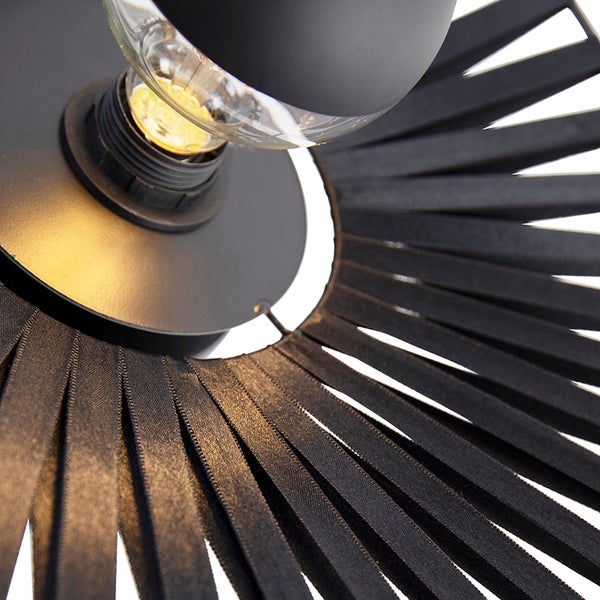 Detailansicht einer Pendelleuchte mit schwarzer Metallbasis und strahlenförmigen schwarzen Stoffbändern um ein klares Leuchtmittel.