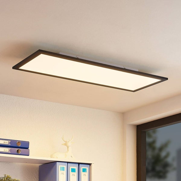 Rechteckiges LED-Deckenpanel mit schwarzem Rahmen in einem hellen Raum über einem Regal mit Ordnern.